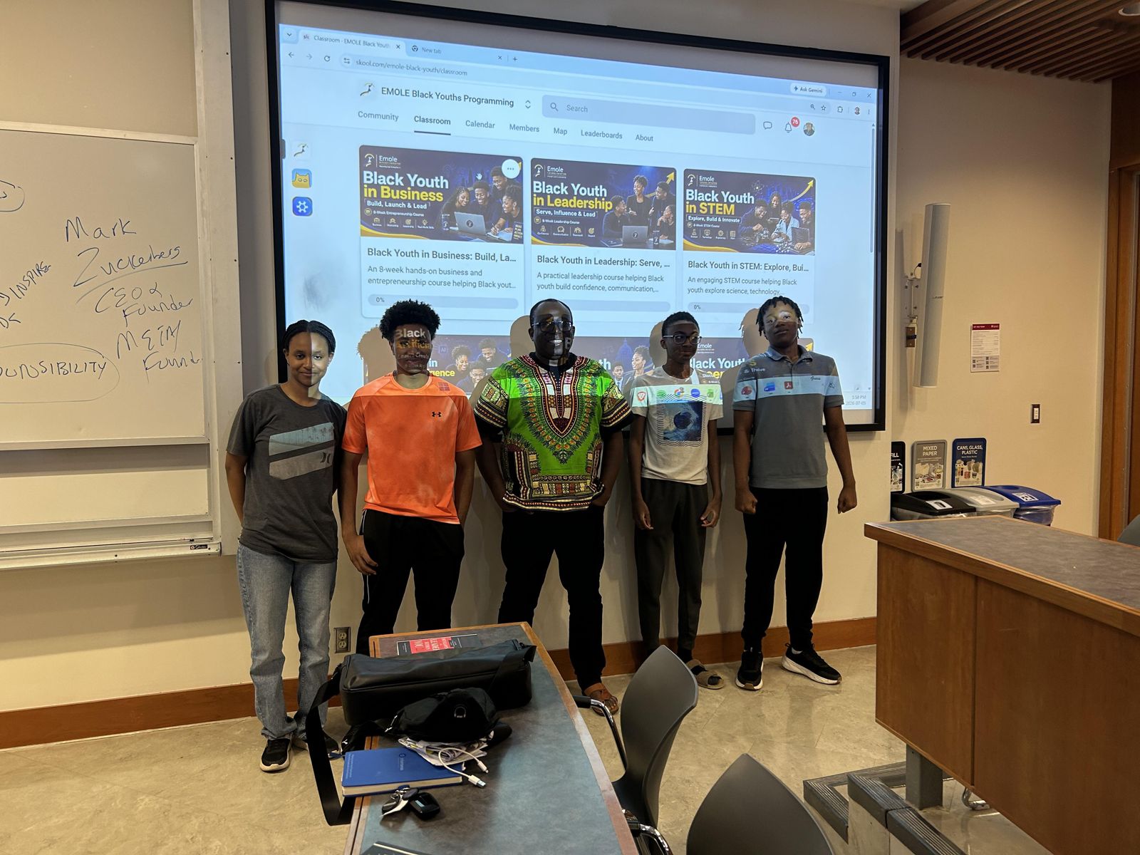 Black Youth in Business students stand together at the front of a classroom.