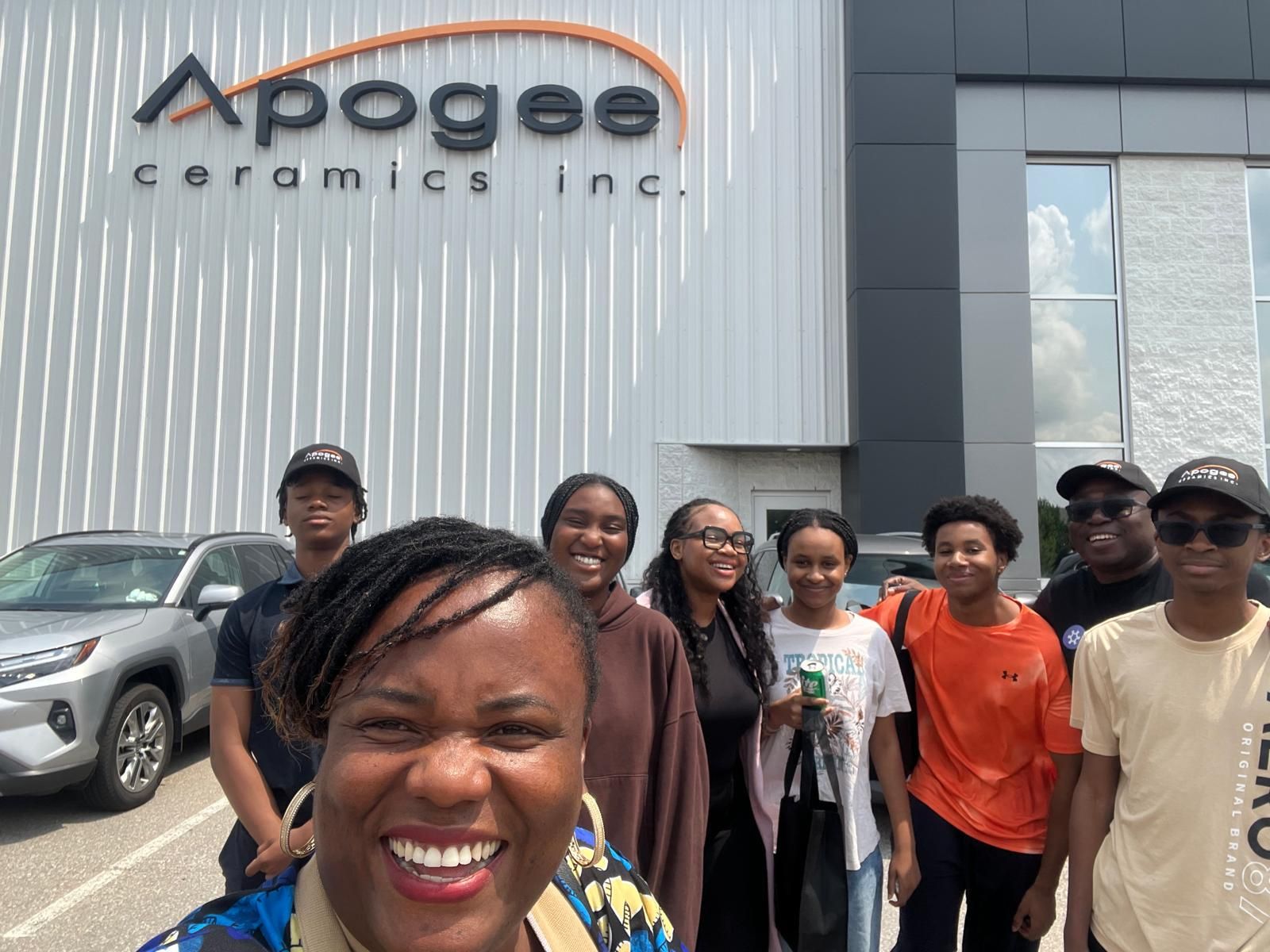 Black Youth in Business students and staff smile together during an industry visit.